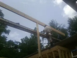 Carpenter setting a ridge beam over a new addition frame — Ice Dam Removal by Roofing Brothers in New Hope