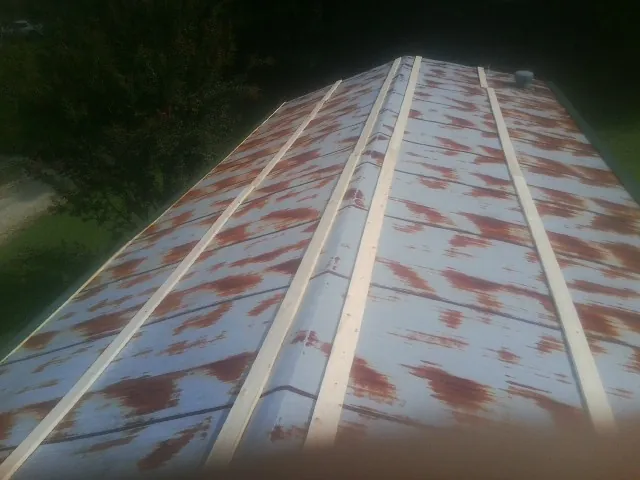 Rusted metal roof panels with new wood purlins before replacement — Storm Damage Roof Repair in New Hope by Roofing Brothers